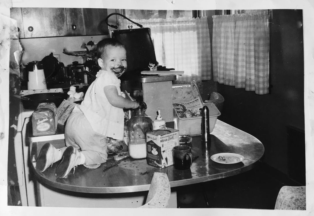 Old photo toddler on counter making chocolate milk mess